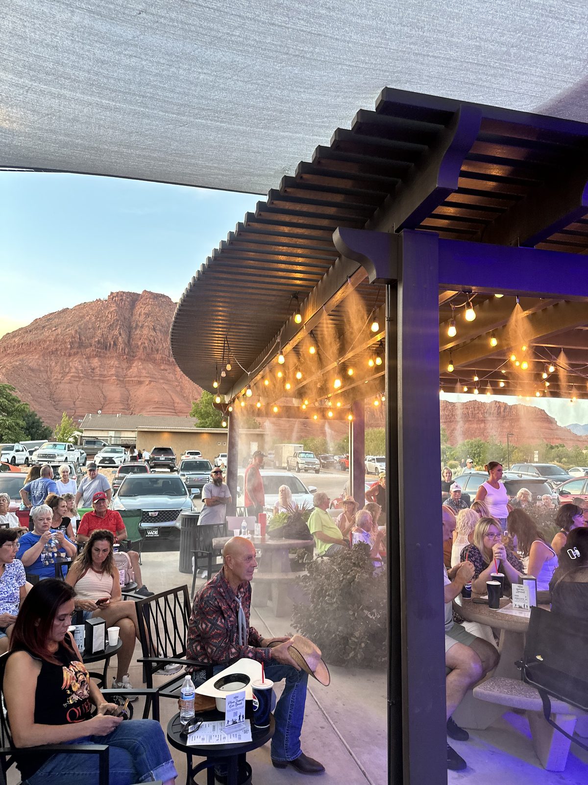 Crowd gathered on the patio with Ivins' red rock mountains in the background