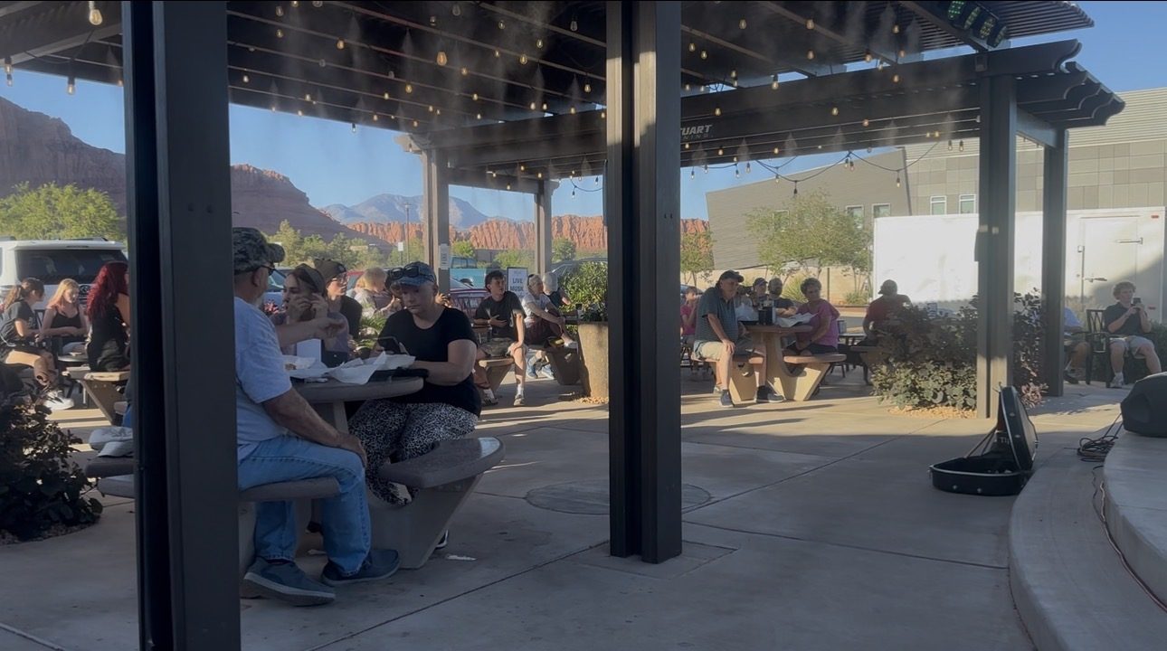 Crowd at picnic tables enjoying a daytime SUMAC event with mountain views