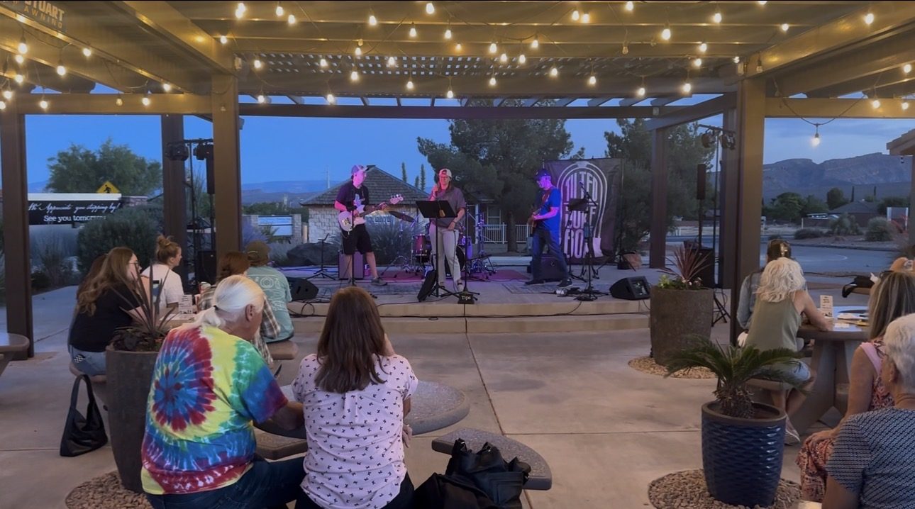 Band performing on the SUMAC stage at dusk with the crowd looking on