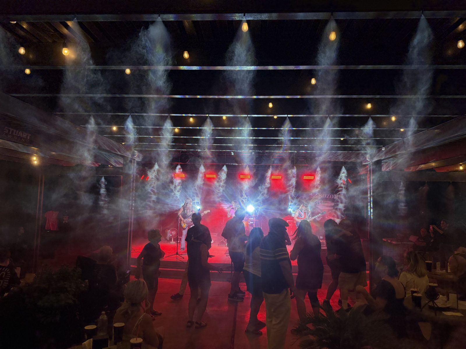 Crowd dancing under misting fans at a SUMAC stage show