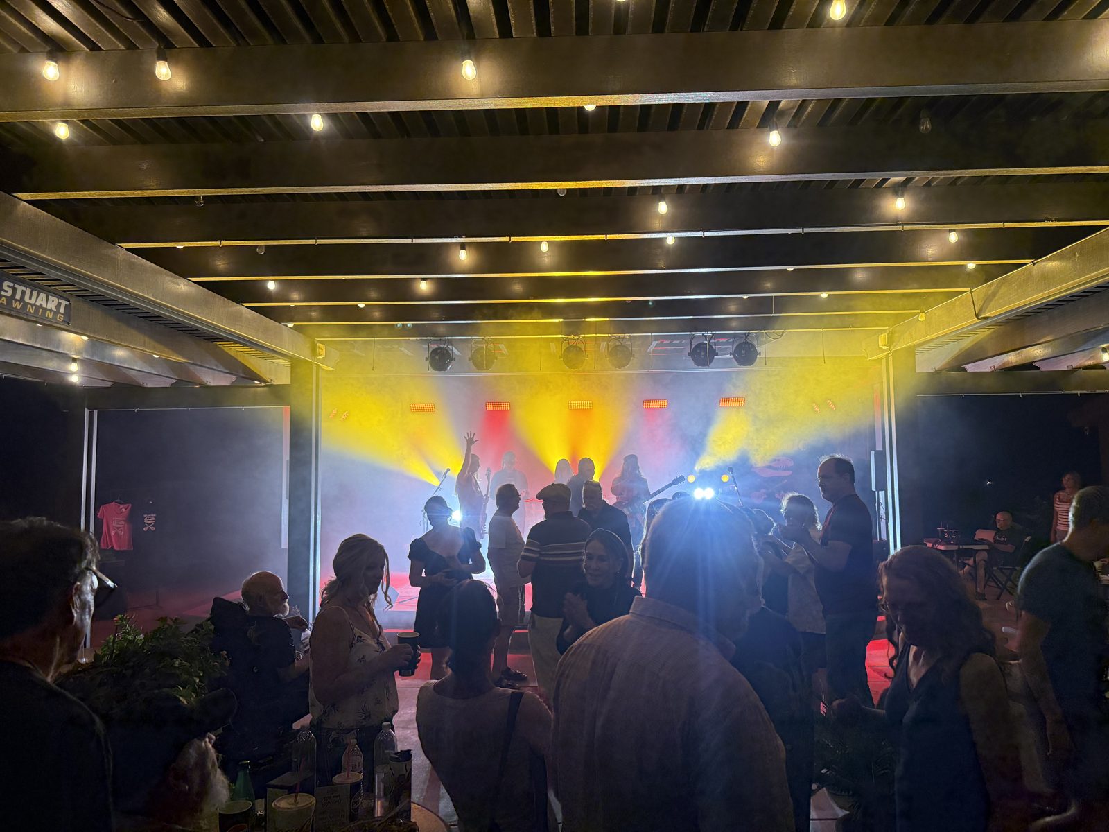 Crowd gathered at the SUMAC stage under string lights and stage fog