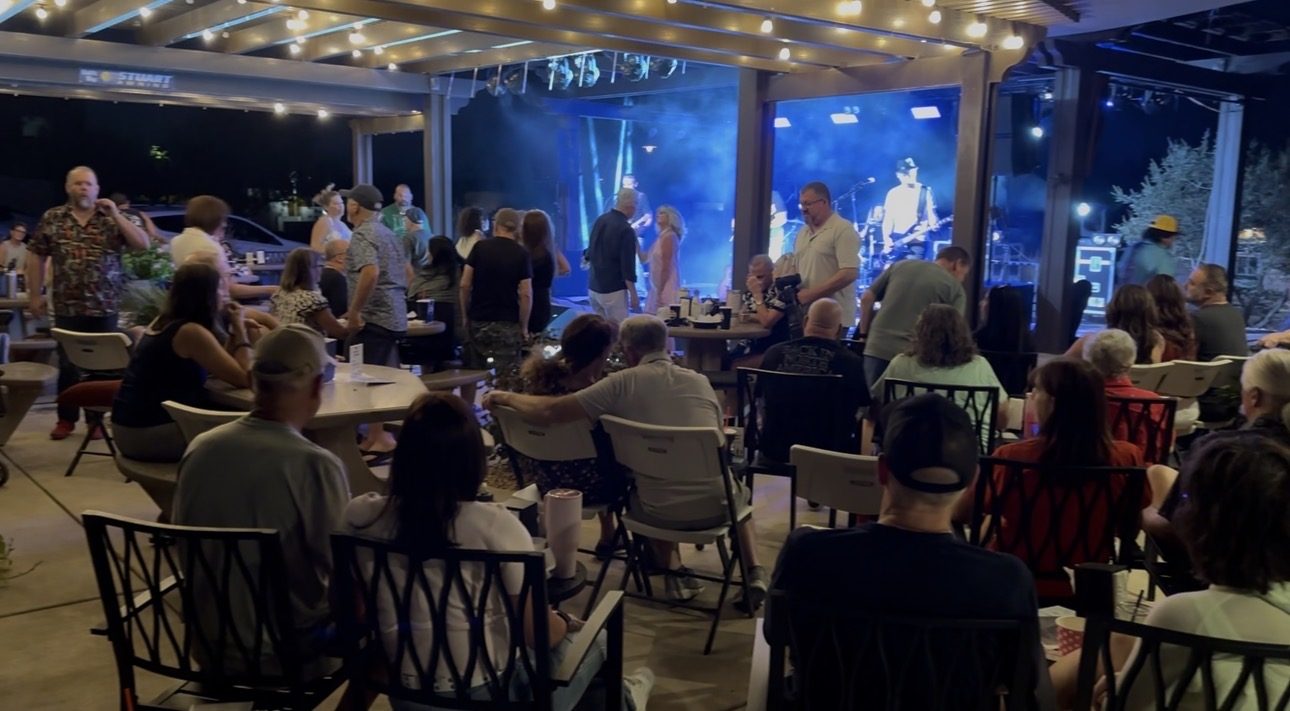 Crowd seated for a SUMAC performance under blue stage lighting