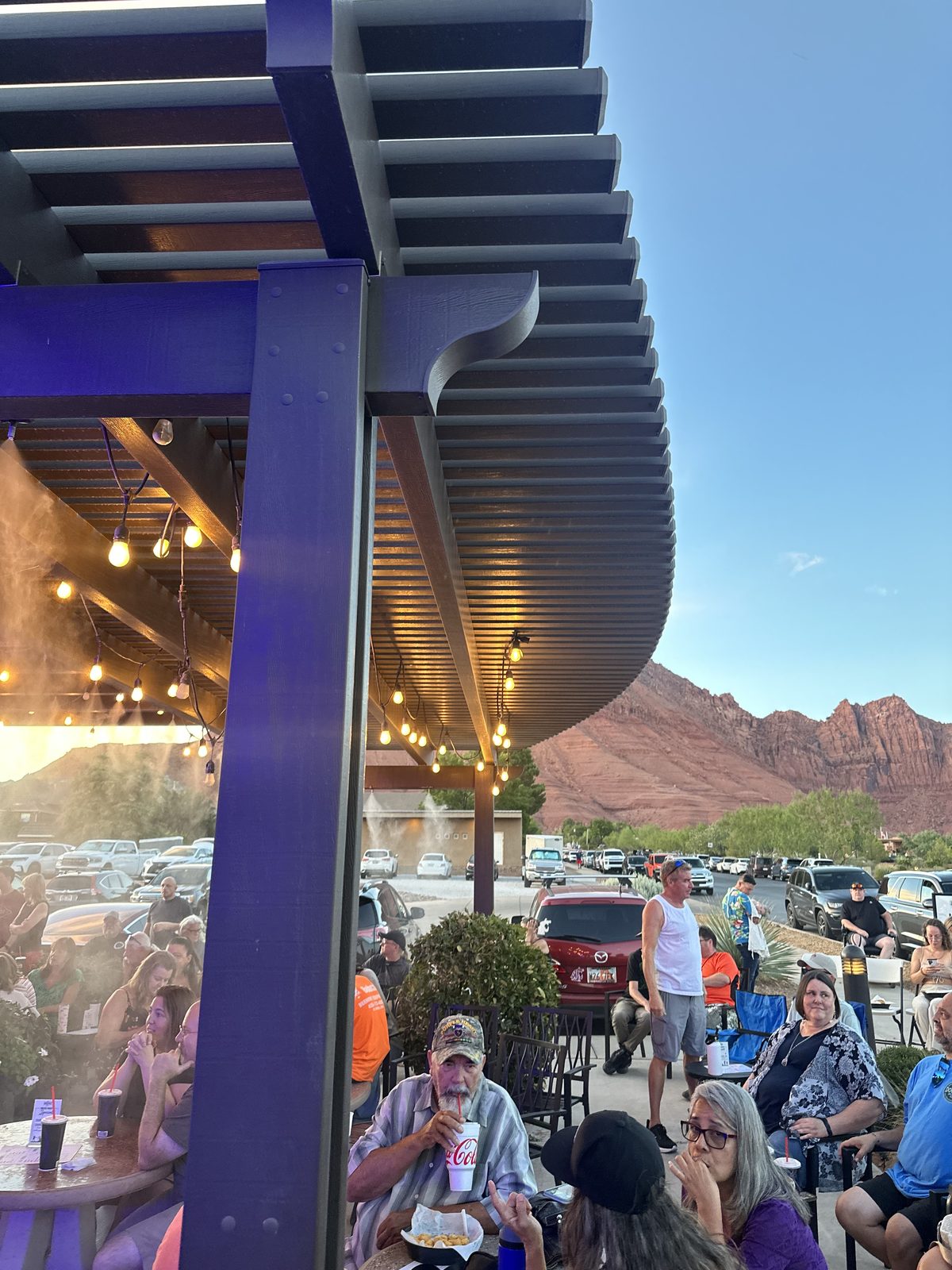 The SUMAC venue pergola with red rock mountains and string lights at sunset